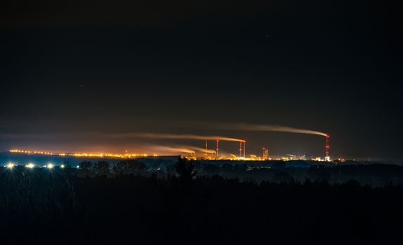 Industrial park at night, Tall chimney with smoke. Police Poland.