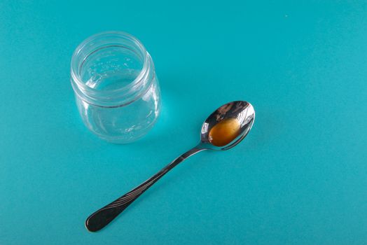 close up of honey jar on blue background