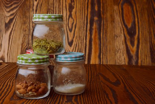 Almonds in a jar on the blue wooden table.