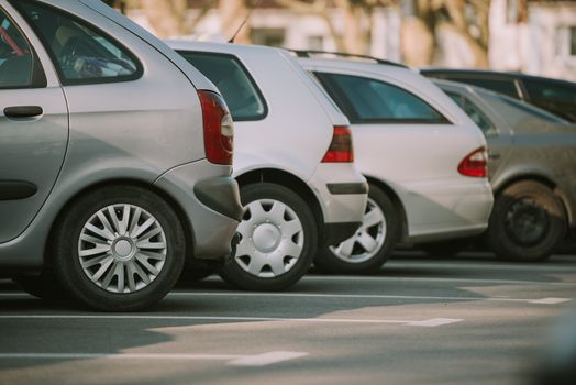 View of tightly packed cars in parking lot.