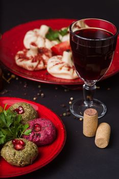 Georgian food on black table. khinkali, phali, adjika and glass of red wine.