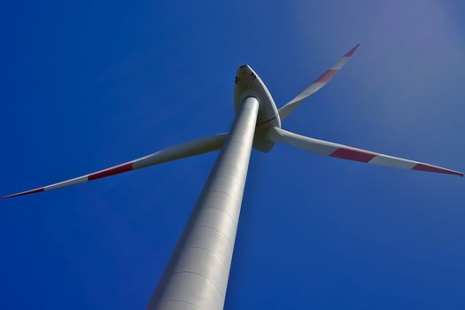 A wind-turbine in front of a clear blue sky