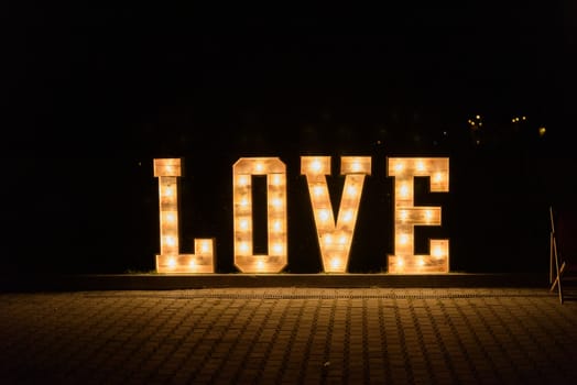 Illuminated Love sign in large letters at a wedding reception.