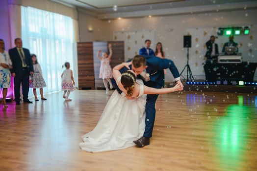 Bride and groom dancing the first dance at their wedding day. Guest on the dancefloor