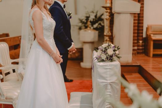 Bride and groom at church wedding during ceremony. Beautiful decoration