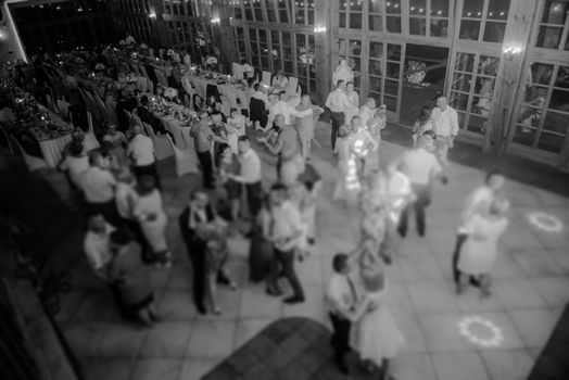 Bride and groom dancing the first dance at their wedding day. Guest on the dancefloor