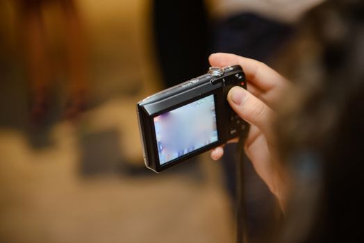 Photo camera in hand taking pictures at wedding party