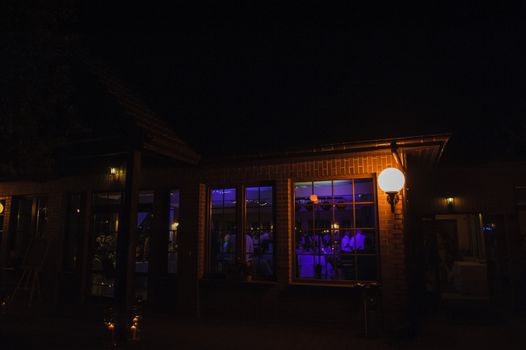 View of restaurants from outside at night. Wedding party.