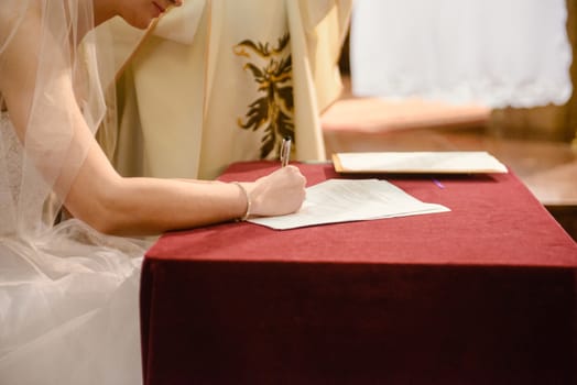 Bride and groom signing wedding contract proving their marriage.