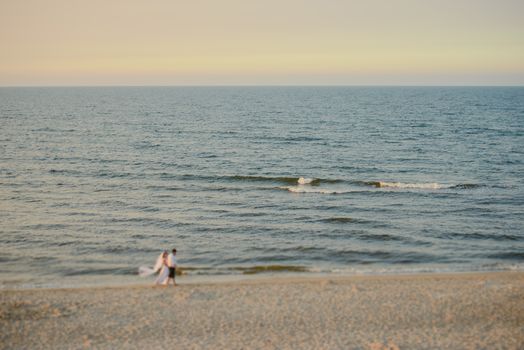 Bride and groom at a photo session in the nature. Baltic sea beach.