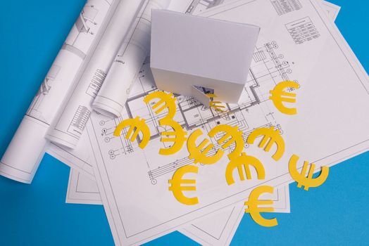 Paper skyscrapers , euro money, house projects plan and blueprints on blue background paper. Minimalistic and simple concept, style. Horizontal orientation. View from above.