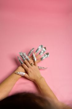 The procedure for removing varnish from nails hybrid nails in progress. Gel nail polish remover foils on woman's hands