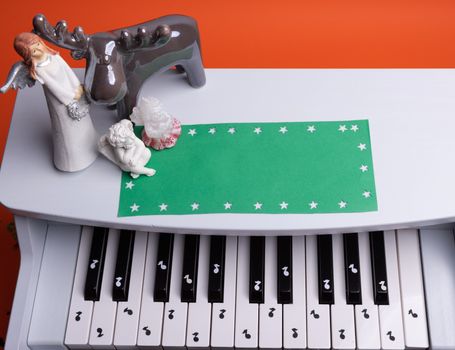 white toy piano with paper notes. music piano concept. view from above. White, black and yellow music notes.