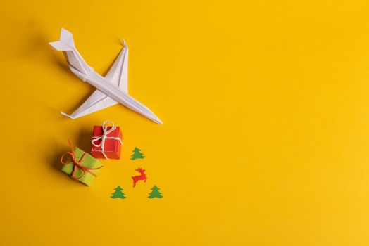Group of paper plane in one direction and with one individual pointing in the different way on yellow background. Christmas ttrip. Presents and gifts