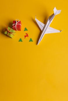Group of paper plane in one direction and with one individual pointing in the different way on yellow background. Christmas ttrip. Presents and gifts