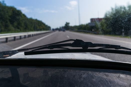 View of a passenger from the passenger compartment on the highway. A fine sunny day and almost free road. 