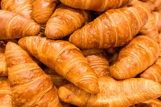 Heap of fresh baked mouthwatering butter croissant pastries, Food texture background