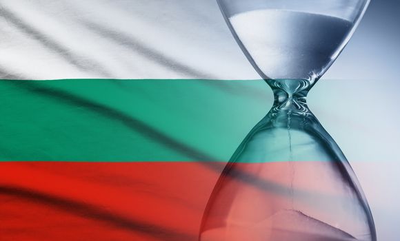 Flag of Bulgaria with superimposed hourglass with running sand conceptual of deadlines, countdown, passing time, urgency, crisis and time management