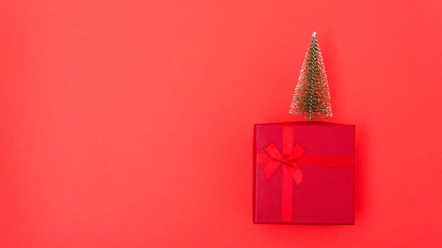 New Year, Christmas Xmas holiday composition, Top view red gift box with green fir tree branch over box on red background