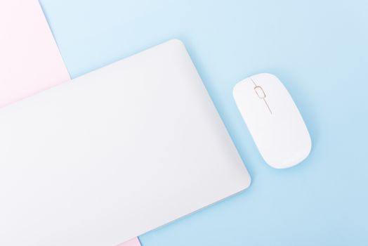 Top view close cover laptop computer notebook and wireless mouse isolated on blue background