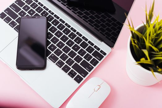 Top view of modern technology smart phone mobile and computer laptop on pink background with copy space