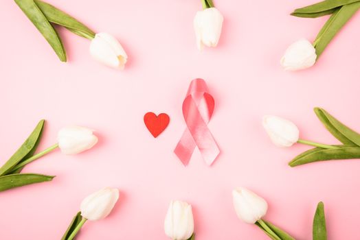 Breast cancer month concept, flat lay top view, pink ribbon and Tulip Flower on pink background with copy space for your text