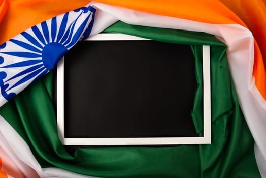 Indian republic day, flat lay top view, Indian flag and photo frame on black background with copy space for your text