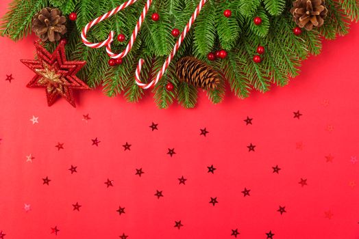 Happy new year or christmas day top view flat lay fir tree branches and ornaments decoration on red background with copy space for your text