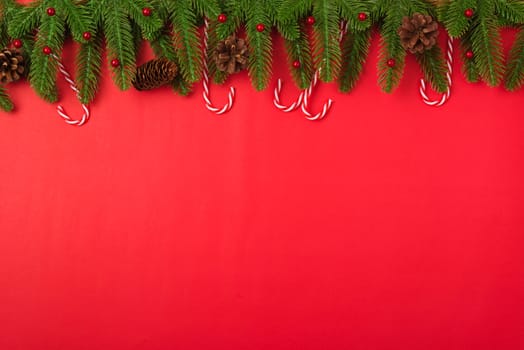 Happy new year or christmas day top view flat lay fir tree branches and decoration on red background with copy space for your text