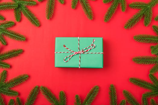 Happy new year or christmas day top view flat lay fir tree branches and gift box, decoration on red background with copy space for your text
