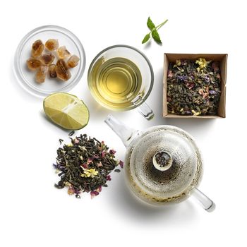 Green tea with natural aromatic additives and accessories. Top view on white background.