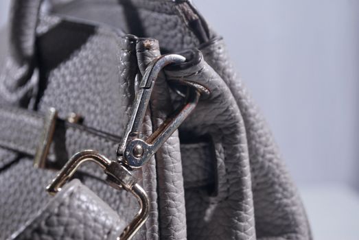 The hook on the edge of the gray leather bag.