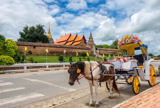 Horse drawn carriage in front of Wat Phra That, Lampang Luang, Thailand for tourist services
