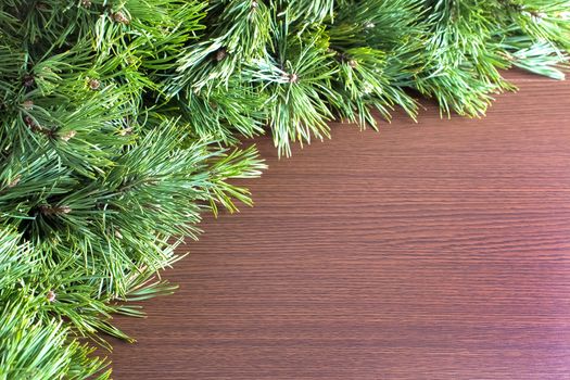 Christmas tree branches on a wooden table with a place for copy space. Flat lay, top view