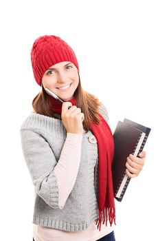 Portrait of a beautiful smiling female student in winter clothes holding a pen and notebooks, isolated on white background.