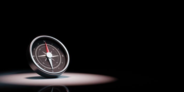 Metallic Compass with Red Magnetic Needle Pointing Toward the North Spotlighted on Black Background with Copy Space 3D Illustration