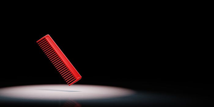 Red Comb Spotlighted on Black Background with Copy Space 3D Illustration