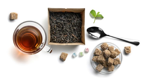 Black tea and accessories top view on white background.