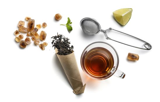 Black tea and accessories top view on white background.