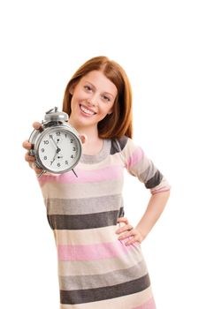 Time concept. Beautiful young girl holding an old-fashioned alarm clock and smiling, isolated on white background. Selective focus on alarm clock.