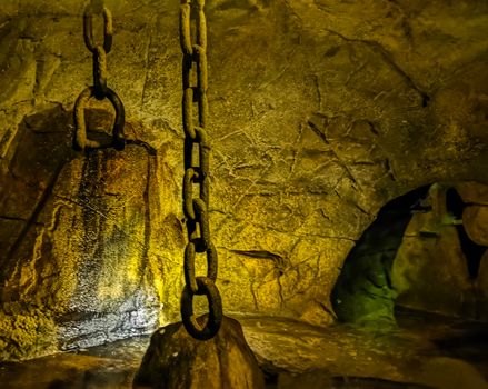 old medieval dungeon with iron chains hanging on the roof, historical architecture