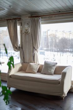 sofa near the window of a large light window, restaurant cozy interior texture of a wooden wall