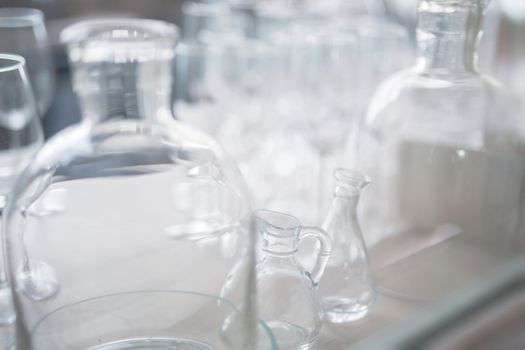 many vintage clear glass bottles are close together, light background