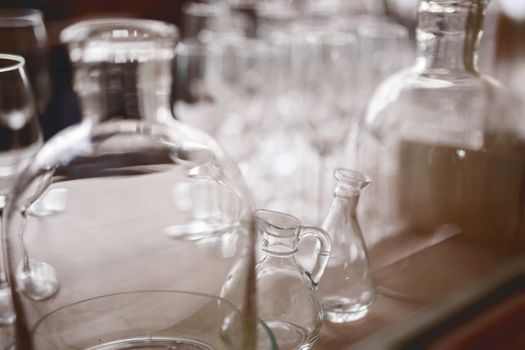 many vintage clear glass bottles are close together, light background