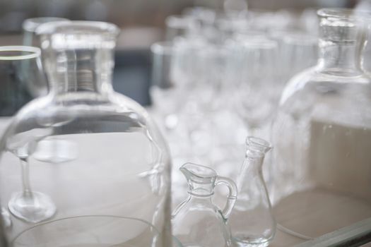 many vintage clear glass bottles are close together, light background