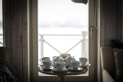 a white tea service stands at the window on a table in a cafe, without people, sugar in a sugar bowl