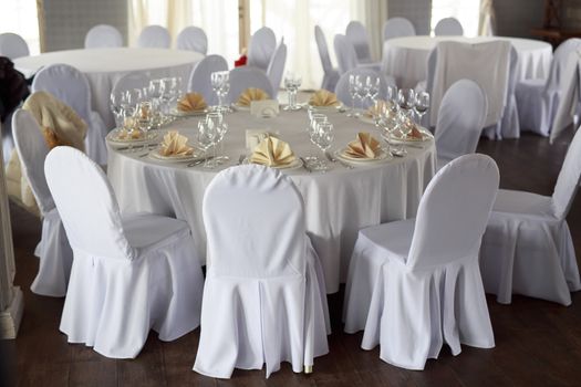 Banquet hall chairs, white tablecloth, food table, table setting, empty wine glasses, Banquet hall without people, wooden floor