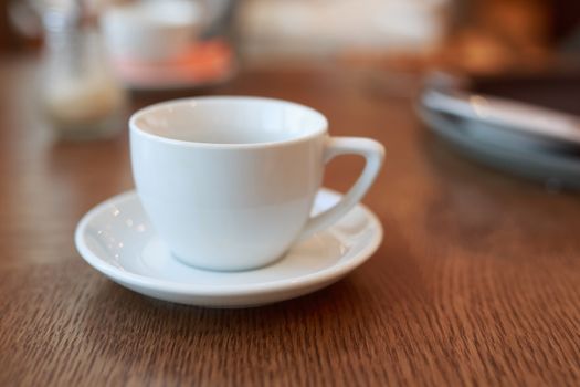 coffee Cup is on the table in a cafe with a blurry background , white tea Cup, Breakfast, cafe background orange