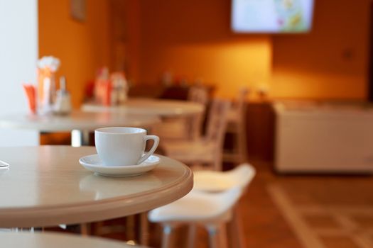 coffee Cup is on the table in a cafe with a blurry background , white tea Cup, Breakfast, cafe background orange