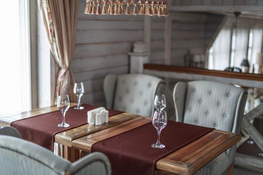 glasses stand on the table restaurant cozy interior texture wooden wall, retro background